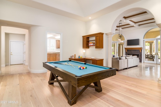 playroom featuring beam ceiling, decorative columns, a high ceiling, coffered ceiling, and light hardwood / wood-style floors