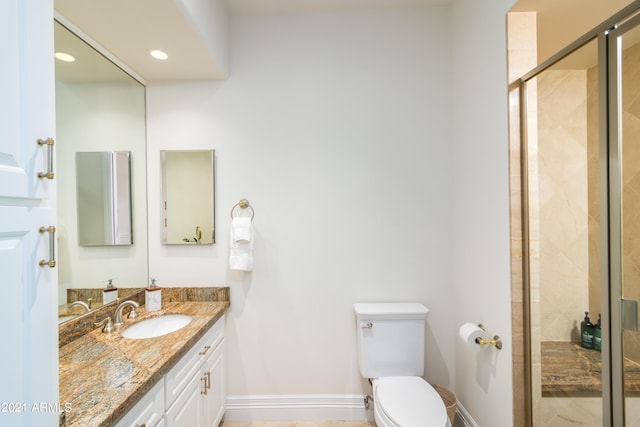 bathroom with vanity, toilet, and a shower with shower door