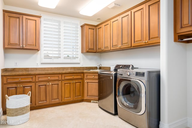 clothes washing area featuring cabinets, separate washer and dryer, and sink