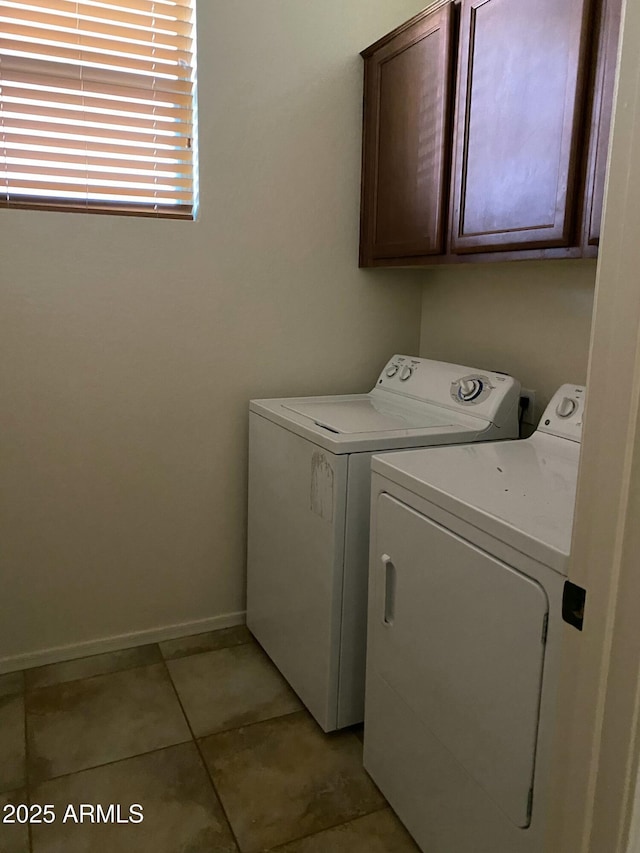 washroom featuring cabinet space, washer and clothes dryer, baseboards, and light tile patterned flooring