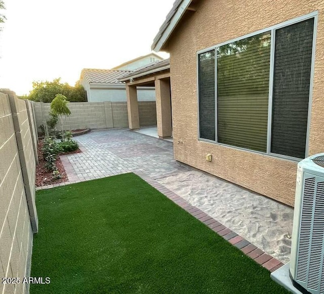 view of yard with a fenced backyard, a patio area, and cooling unit