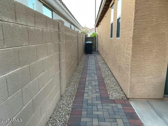 view of side of property with fence and stucco siding