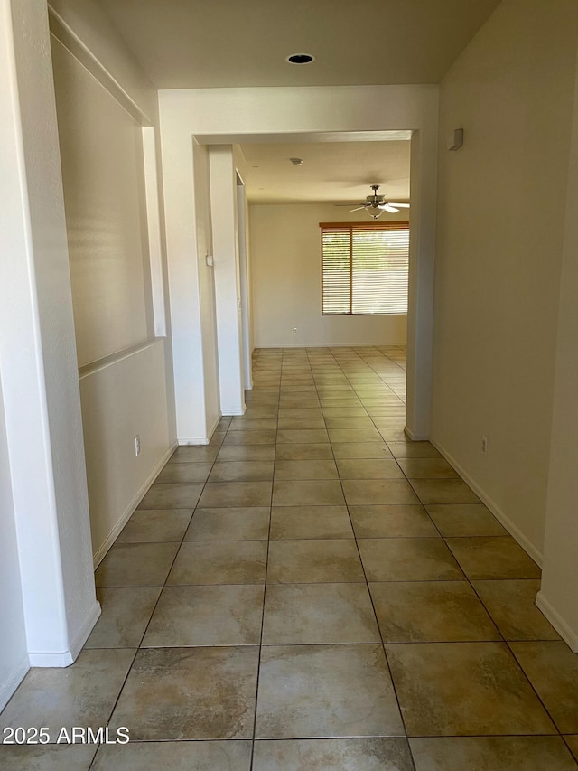 hallway with tile patterned flooring and baseboards