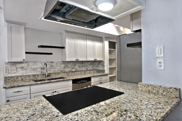 kitchen with sink, white cabinets, light stone counters, and decorative backsplash