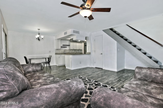 living room featuring ceiling fan with notable chandelier and dark hardwood / wood-style flooring