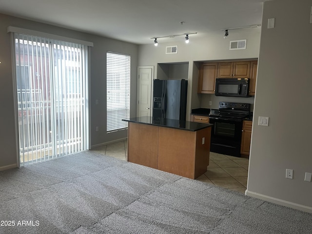 kitchen featuring a center island, light tile patterned floors, black appliances, and track lighting