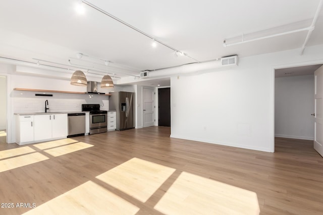 unfurnished living room featuring light hardwood / wood-style floors and sink