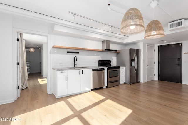 kitchen with pendant lighting, decorative backsplash, sink, white cabinetry, and stainless steel appliances