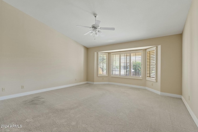 empty room with ceiling fan and light colored carpet