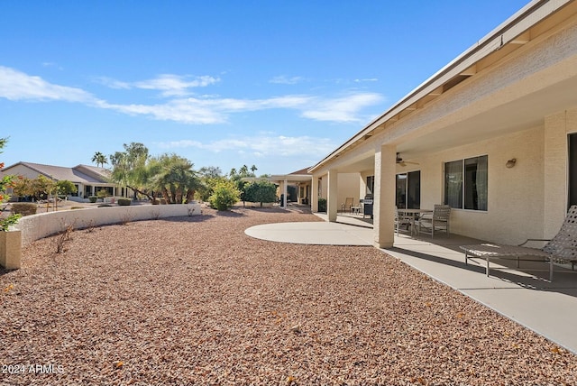 view of yard featuring ceiling fan and a patio