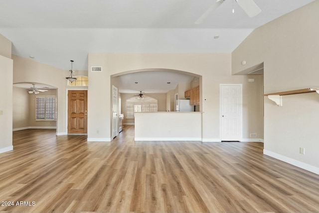 unfurnished living room with lofted ceiling and light wood-type flooring