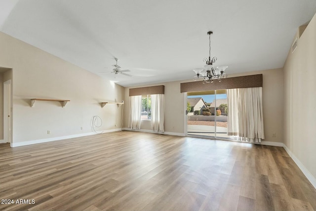 spare room with wood-type flooring and ceiling fan with notable chandelier