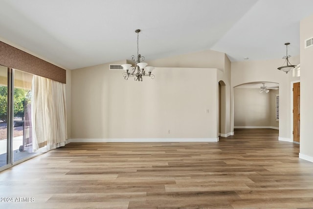 unfurnished dining area with ceiling fan with notable chandelier, light hardwood / wood-style floors, and lofted ceiling