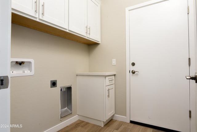 laundry room with electric dryer hookup, washer hookup, cabinets, and light wood-type flooring