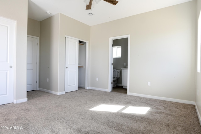 unfurnished bedroom featuring light carpet, ceiling fan, and ensuite bathroom