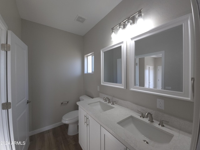 bathroom featuring vanity, hardwood / wood-style flooring, and toilet