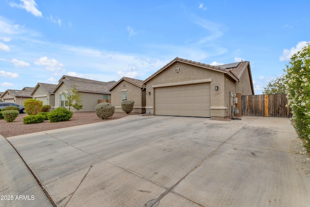 view of front of home with a garage, solar panels, stucco siding, and concrete driveway