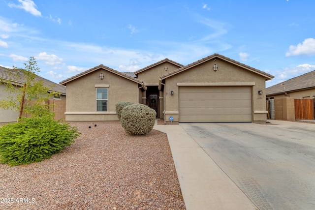 view of front of home with stucco siding, concrete driveway, a garage, fence, and a tile roof