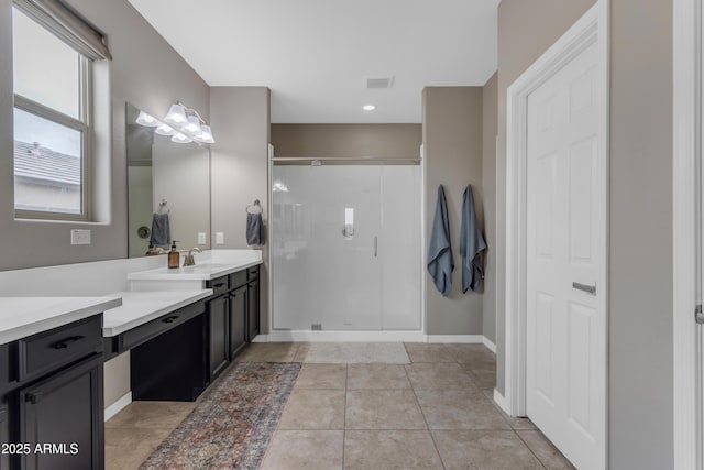 bathroom featuring vanity, a stall shower, baseboards, and tile patterned flooring