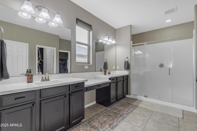 full bath featuring a shower stall, tile patterned floors, vanity, and a walk in closet