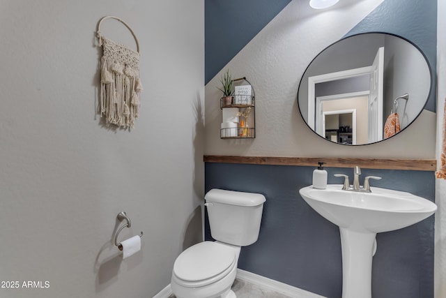 half bath featuring toilet and a sink