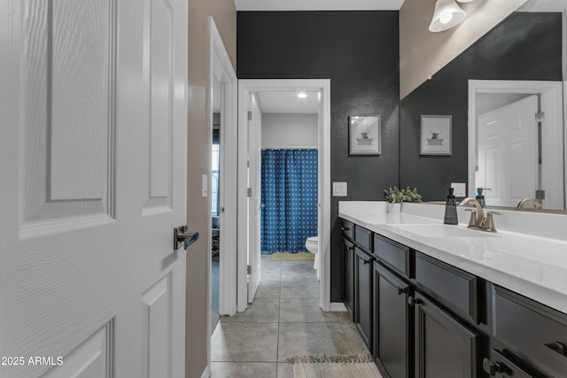 bathroom with toilet, vanity, and tile patterned floors