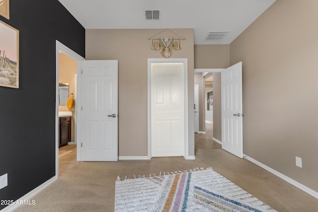 unfurnished bedroom featuring light carpet, baseboards, and a chandelier