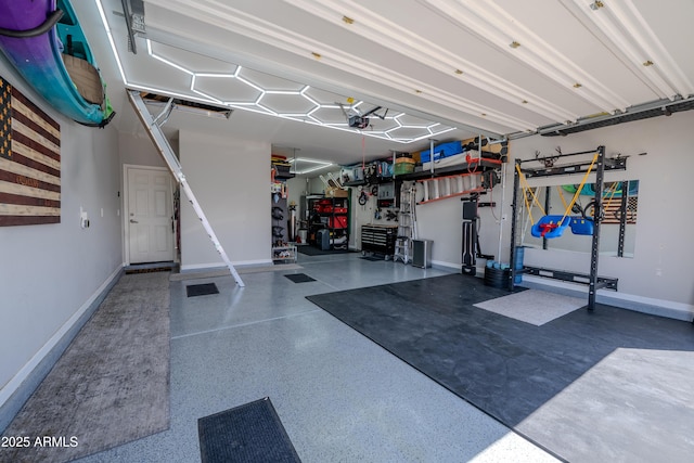 garage with baseboards, a garage door opener, and a workshop area