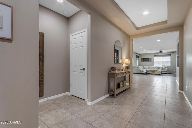 hallway featuring light tile patterned flooring, baseboards, and recessed lighting