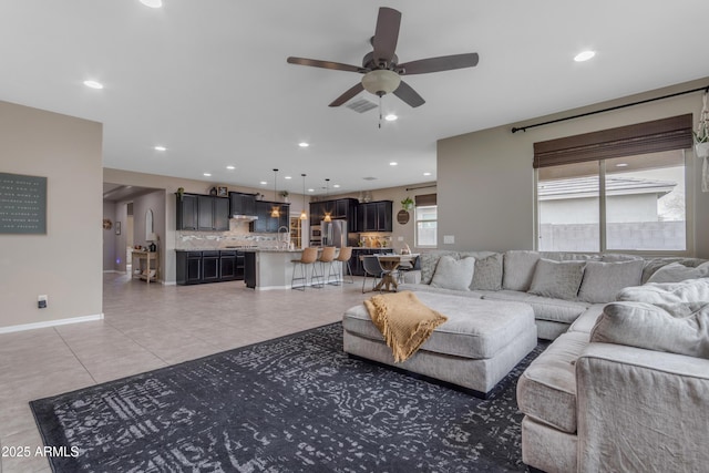 living area with light tile patterned floors, ceiling fan, recessed lighting, and baseboards