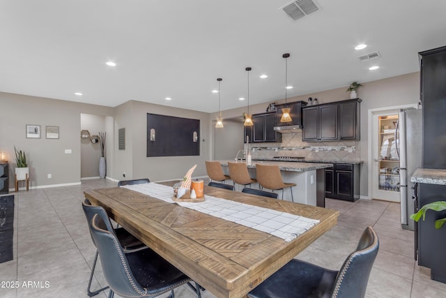 dining space featuring light tile patterned flooring, recessed lighting, and baseboards