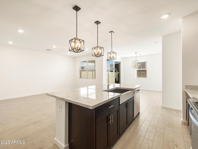 kitchen featuring stainless steel appliances, a chandelier, light wood-type flooring, and a sink