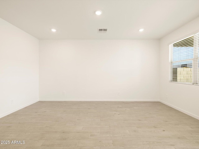 spare room with light wood finished floors, visible vents, baseboards, and recessed lighting