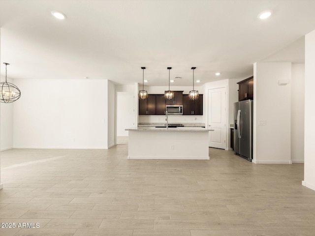 kitchen featuring recessed lighting, open floor plan, light countertops, and appliances with stainless steel finishes