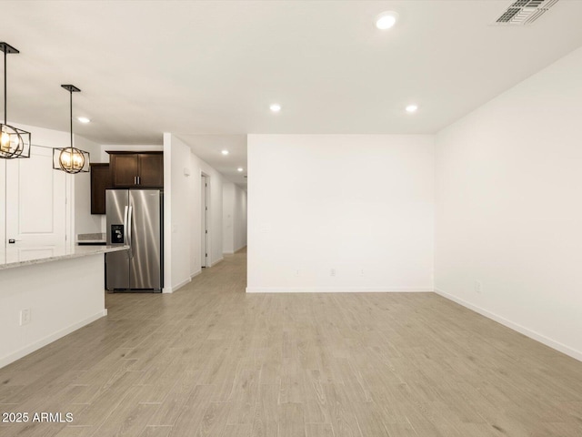 unfurnished living room featuring baseboards, recessed lighting, and visible vents