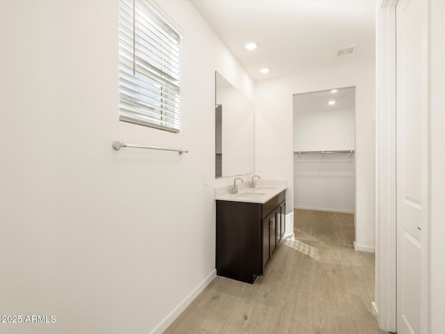 bathroom with recessed lighting, baseboards, visible vents, vanity, and wood finished floors