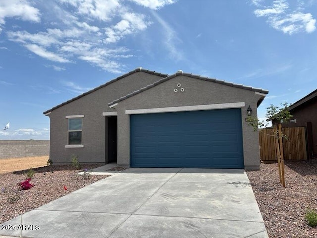 ranch-style home featuring concrete driveway, a garage, stucco siding, and fence