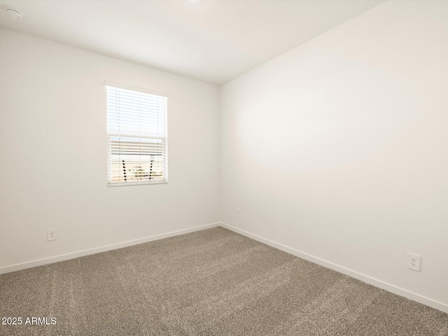 spare room featuring baseboards and carpet floors
