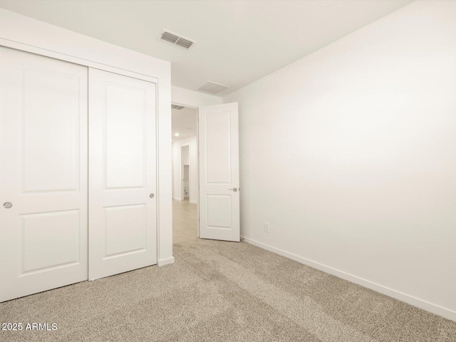 unfurnished bedroom featuring carpet, visible vents, baseboards, and a closet