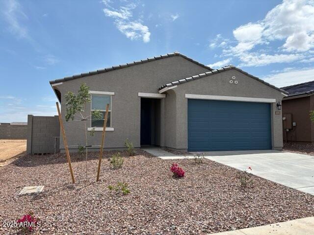 ranch-style home with fence, driveway, a tile roof, a garage, and stucco siding