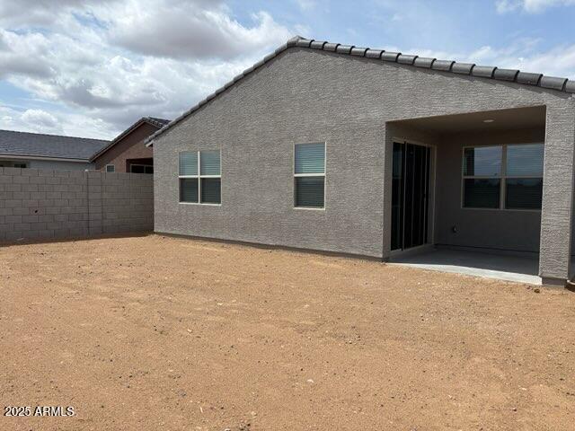 back of house with fence, a patio, and stucco siding