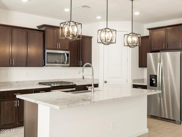 kitchen featuring visible vents, a chandelier, hanging light fixtures, dark brown cabinets, and appliances with stainless steel finishes