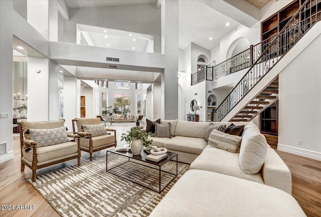 living room featuring beam ceiling, hardwood / wood-style floors, and high vaulted ceiling