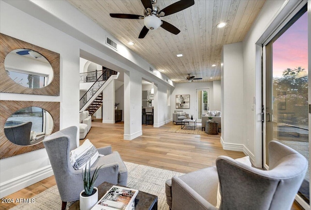 living room featuring ceiling fan, wooden ceiling, and light hardwood / wood-style flooring