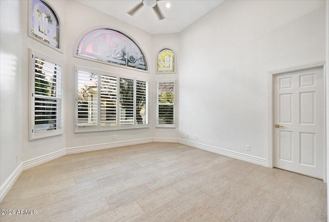 unfurnished room with ceiling fan and a high ceiling