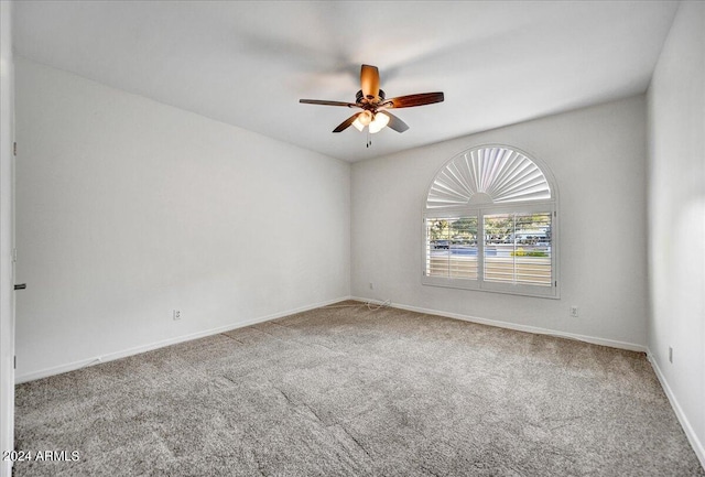 carpeted spare room featuring ceiling fan