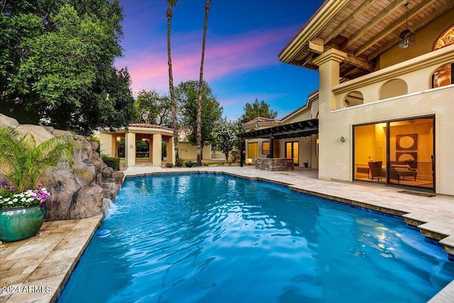 pool at dusk with a patio