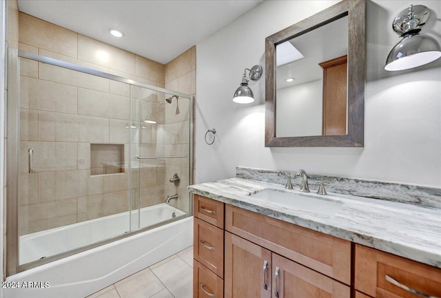 bathroom featuring tile patterned flooring, vanity, and enclosed tub / shower combo