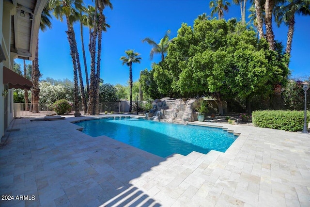 view of swimming pool with pool water feature and a patio area