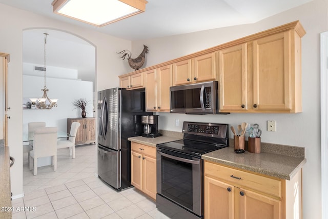 kitchen with light tile patterned floors, light brown cabinetry, stainless steel appliances, and lofted ceiling